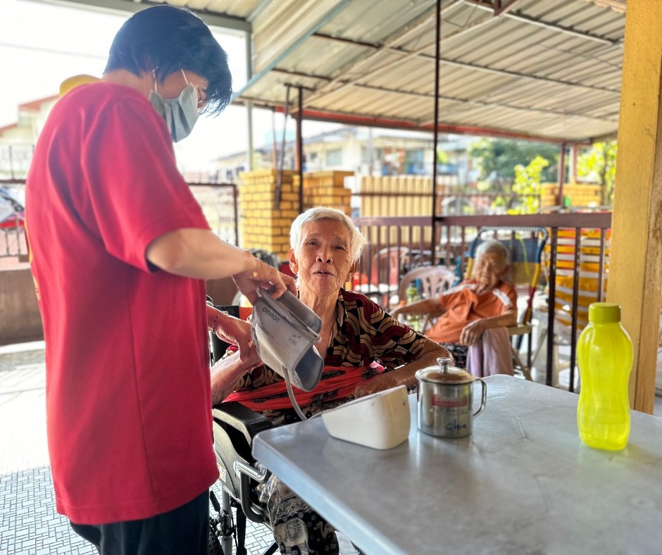 Amitabha staff conducting health screening for elderly resident
