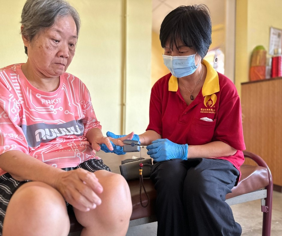 Amitabha staff providing health screening to elderly resident